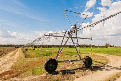 Irrigation equipment on field against sky