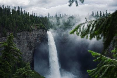 Scenic view of waterfall against sky