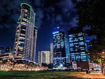 Low angle view of illuminated buildings against sky at night