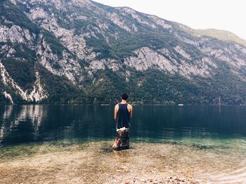 Full length of man standing on lake against mountain