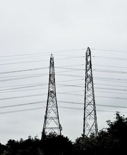 Low angle view of silhouette electricity pylon against clear sky