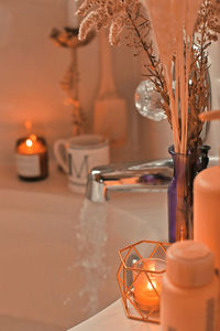 Close-up of lit candle on table at home