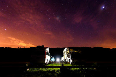 Scenic view of illuminated field against sky at night