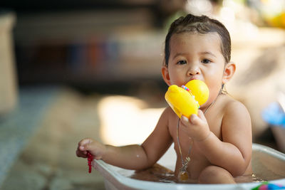 Bath time is fun. selective focus image of a cute little girl taking a bath and playing with rubber