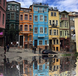 Buildings by canal against sky in city