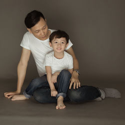 Smiling cute boy sitting on lap of father