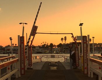 Narrow walkway along calm sea at sunset