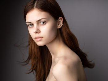 Portrait of beautiful young woman against black background