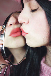 Young woman wearing kissing mirror