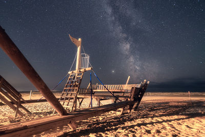 Ferris wheel on land against sky at night