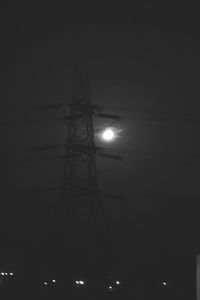 Low angle view of electricity pylon at night