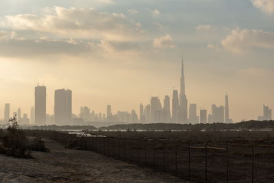 Buildings in city against sky during sunset