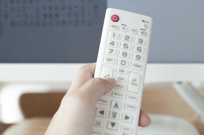 Close-up of hand holding remote control