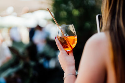 Midsection of woman holding wineglass