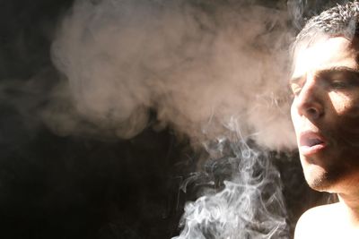 Close-up of man smoking indoors
