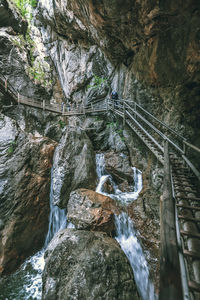 Footbridge on rocky mountain in forest