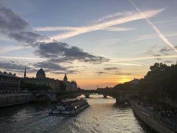 Bridge over river against cloudy sky during sunset