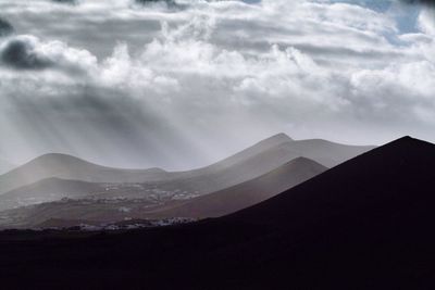 Scenic view of mountains against cloudy sky