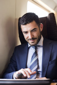 Businessman using tablet computer in train