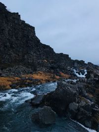 Rock formations by sea against sky