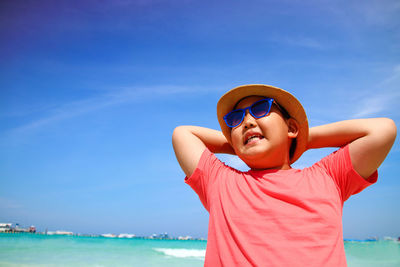 Portrait of boy wearing sunglasses against blue sea