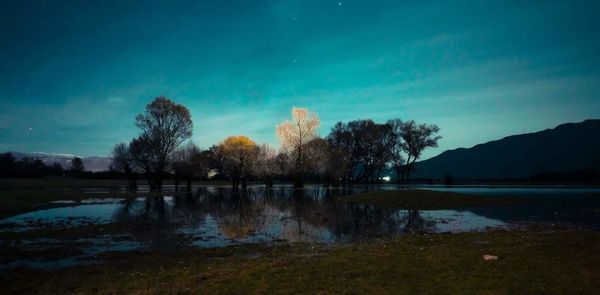 Scenic view of lake against sky at night