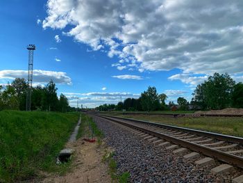 Railroad track amidst field against sky