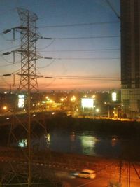 Electricity pylon against sky at dusk