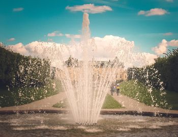 Fountain by trees against sky