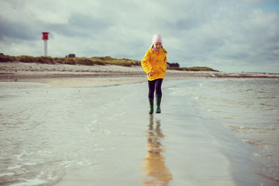 Woman standing on beach against sky