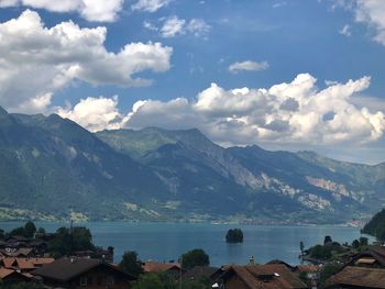 Scenic view of townscape by mountains against sky