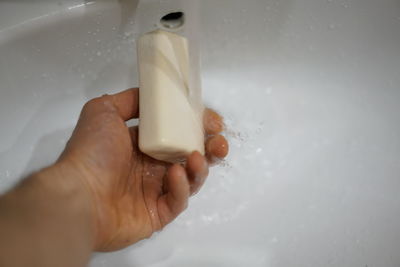 Midsection of person holding hands in bathroom