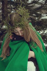 Close-up of young woman with leaves on head during winter