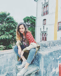 Portrait of smiling young woman sitting outdoors