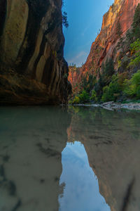 Scenic view of lake by rock formation against sky