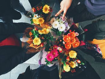 High angle view of friends with flower bouquets while standing on footpath