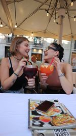 Young woman drinking drink at restaurant