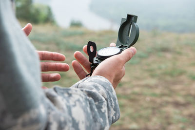 Close-up of man holding camera on field