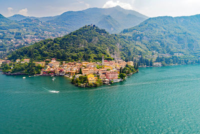 Scenic view of sea by city against mountains