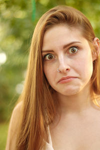 Portrait of surprised beautiful woman standing at park