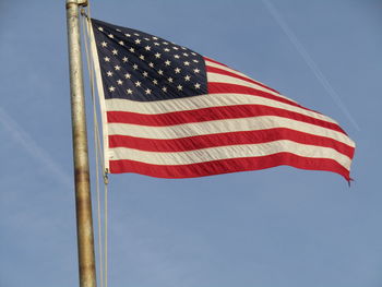 Low angle view of flag against blue sky