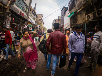 Rear view of people walking on street in city