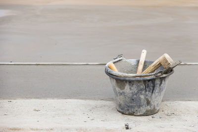 Close-up of trowel in bucket on footpath