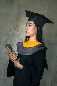 Young woman standing against wall