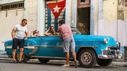 Friends with vintage car on street