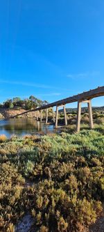 Bridge over river against clear blue sky