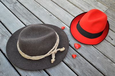 High angle view of heart shapes and sun hats on wooden table