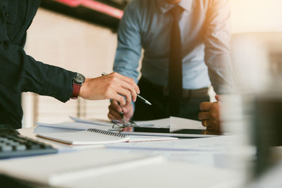 Midsection of colleagues at desk in office