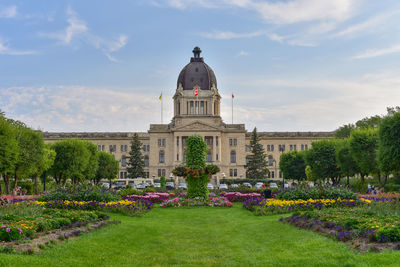 View of flowering plants in garden against cloudy sky