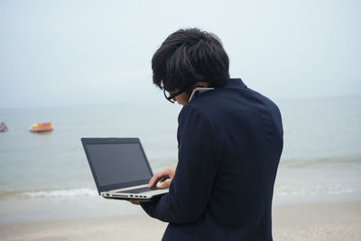 Rear view of man standing on beach